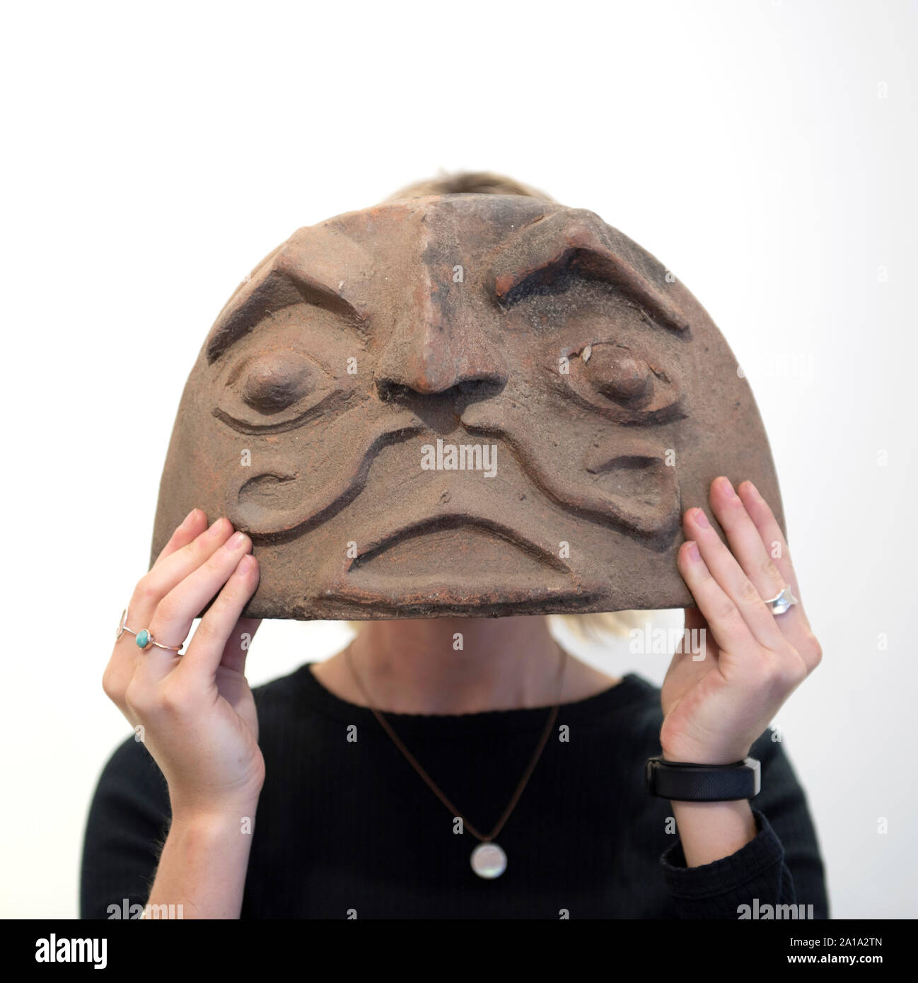 Bonhams, Knightsbridge, London, UK. 25. September 2019. Innendekorateur Christopher Hodsoll ist für seine ursprünglichen und eklektischen Geschmack bekannt und für seine lange Liste von berühmten Kunden, darunter Paul Simon, Elton John, Sting und Mick Jagger. Bild: Bonhams Personal mit einer außergewöhnlichen Sammlung von zwanzig Terrakotta herd Masken, wahrscheinlich Mongolisch, Schätzung £ 500-700. Credit: Malcolm Park/Alamy Leben Nachrichten. Stockfoto