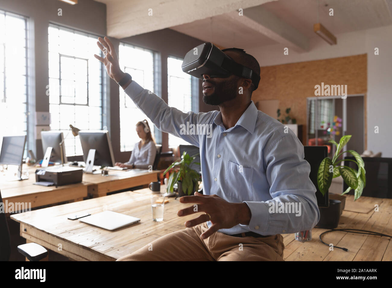 Junge kreative Professionelle man mit VR-Headset in einem sonnendurchfluteten Büro Stockfoto