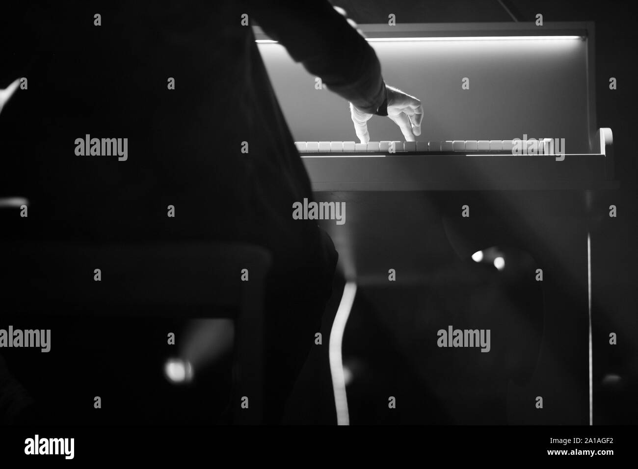 Der Pianist führt eine musikalische Arbeit auf dem Klavier auf der Bühne Stockfoto