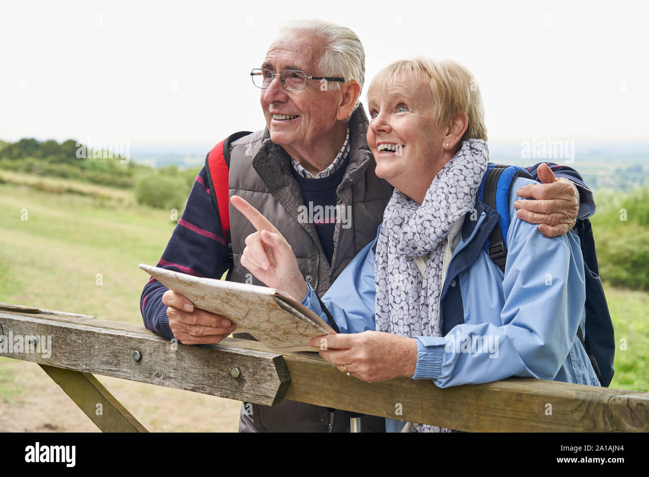 Senior Paar auf Wanderurlaub auf Gate bei Map im Ruhestand Stockfoto Senior Paar auf Wanderurlaub auf Gate bei Map im Ruhestand Stockfoto