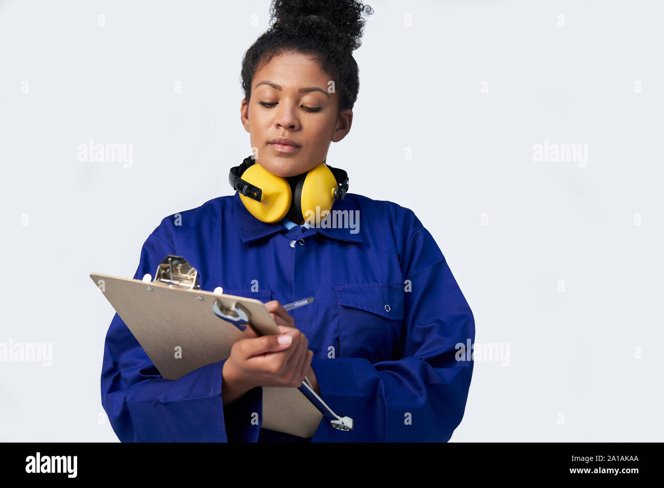 Studio Shot der Ingenieurin mit Klemmbrett und Schraubenschlüssel gegen den weißen Hintergrund Stockfoto