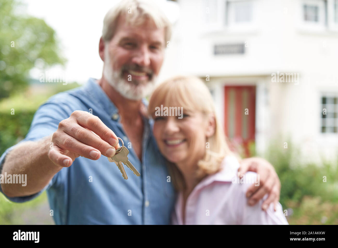 Portrait von Reifes Paar im Garten stand Vor der Traumhaus in die Landschaft halten Tasten Stockfoto