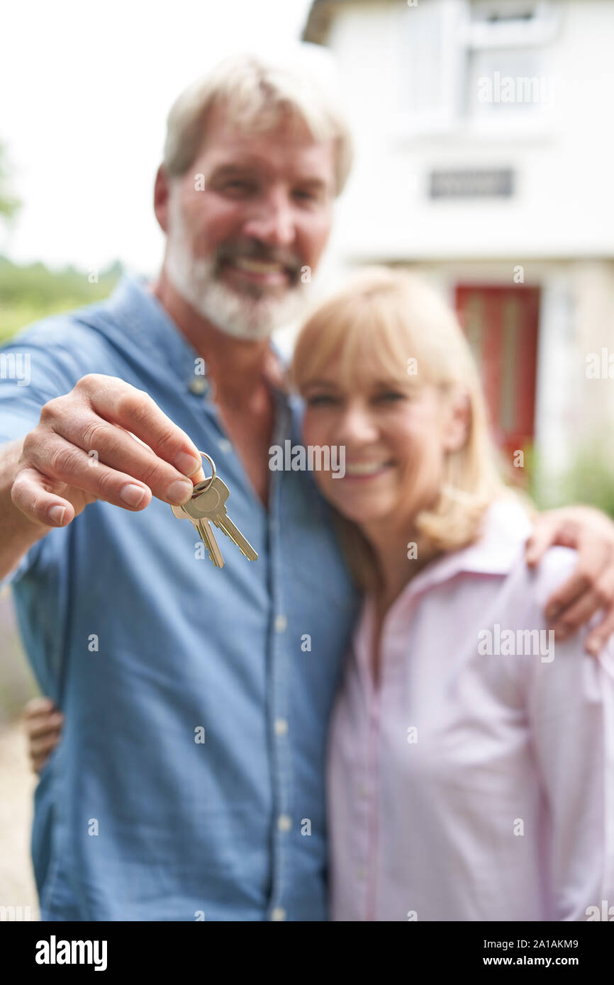 Portrait von Reifes Paar im Garten stand Vor der Traumhaus in die Landschaft halten Tasten Stockfoto