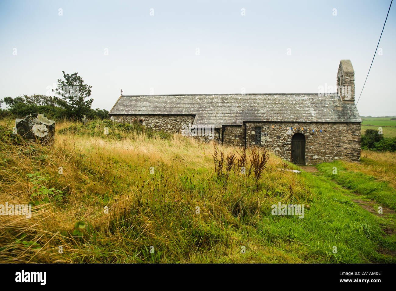St Teilo's Kirche, [St Eloi's Church] Llandeloy, eine redundante Kirche im Dorf Llandeloy, Pembrokeshire, Wales, gewidmet Saint Teilo. Die Kirche vermutlich im 12. Jahrhundert entstanden und diente später als die Dorfschule. Aber von den 1840er Jahren war es eine Ruine. Es wurde 1926 wieder aufgebaut - 27 aus den Ruinen, und durch den Architekten John Coates Carter entwickelt. Das design Kunst und Kunsthandwerk Grundsätze, die einfachsten verfügbaren lokalen Materialien zu verwenden, ohne zu versuchen, den Stil für einen bestimmten Zeitraum zu kopieren. Nachdem die Kirche im Jahr 2002 geschlossen wurde, wurde es in die Obhut des Frie genommen Stockfoto