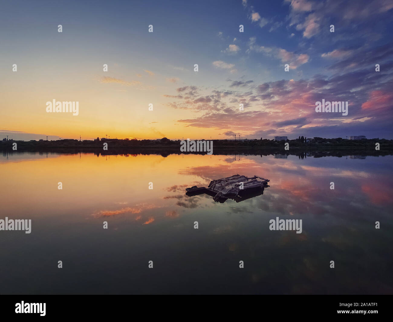 Fine Art Shot mit einem alten, rostigen Katamaran Rahmen auf den Teich vergessen. Landschaft Landschaft, friedlichen Sonnenuntergang Himmel Hintergrund mit bunten Wolken spiegeln Stockfoto