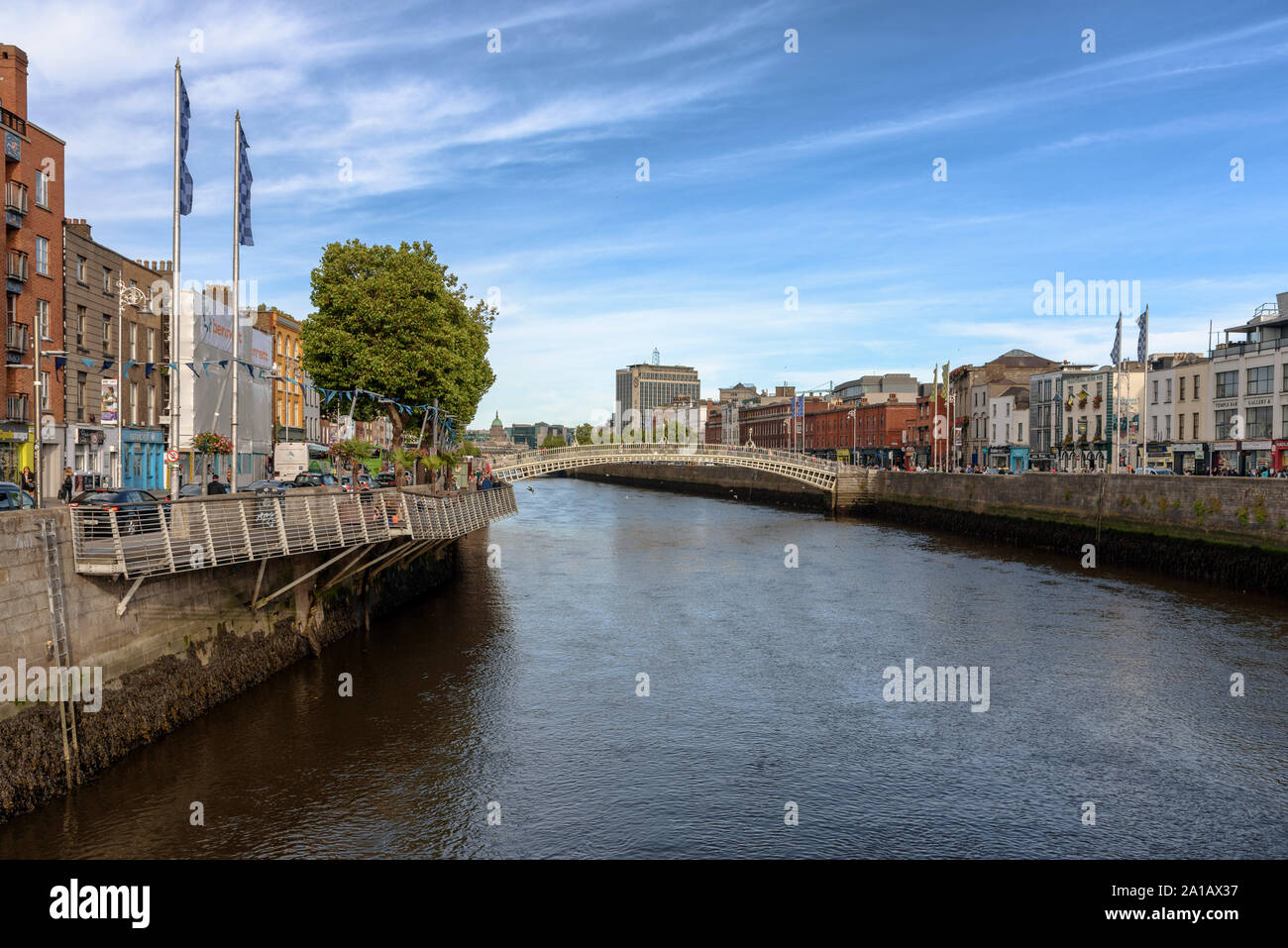 Die liffey Boardwalk und die Ha'Penny Bridge über den Fluss Liffey im Zentrum von Dublin, Irland an einem sonnigen Sommertag Stockfoto