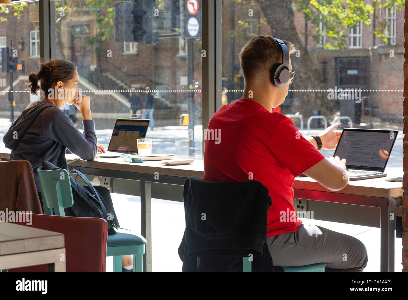 Studierende, die auf Laptops in den lokalen Café, Tottenham Court Road, Westminster, London Borough von Camden, Greater London, England, Vereinigtes Königreich Stockfoto