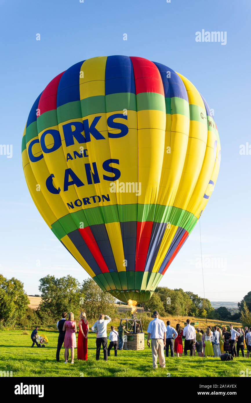 Heißluft-Ballon abheben im Feld in der Nähe von Brannenburg, Devon, England, Vereinigtes Königreich Stockfoto