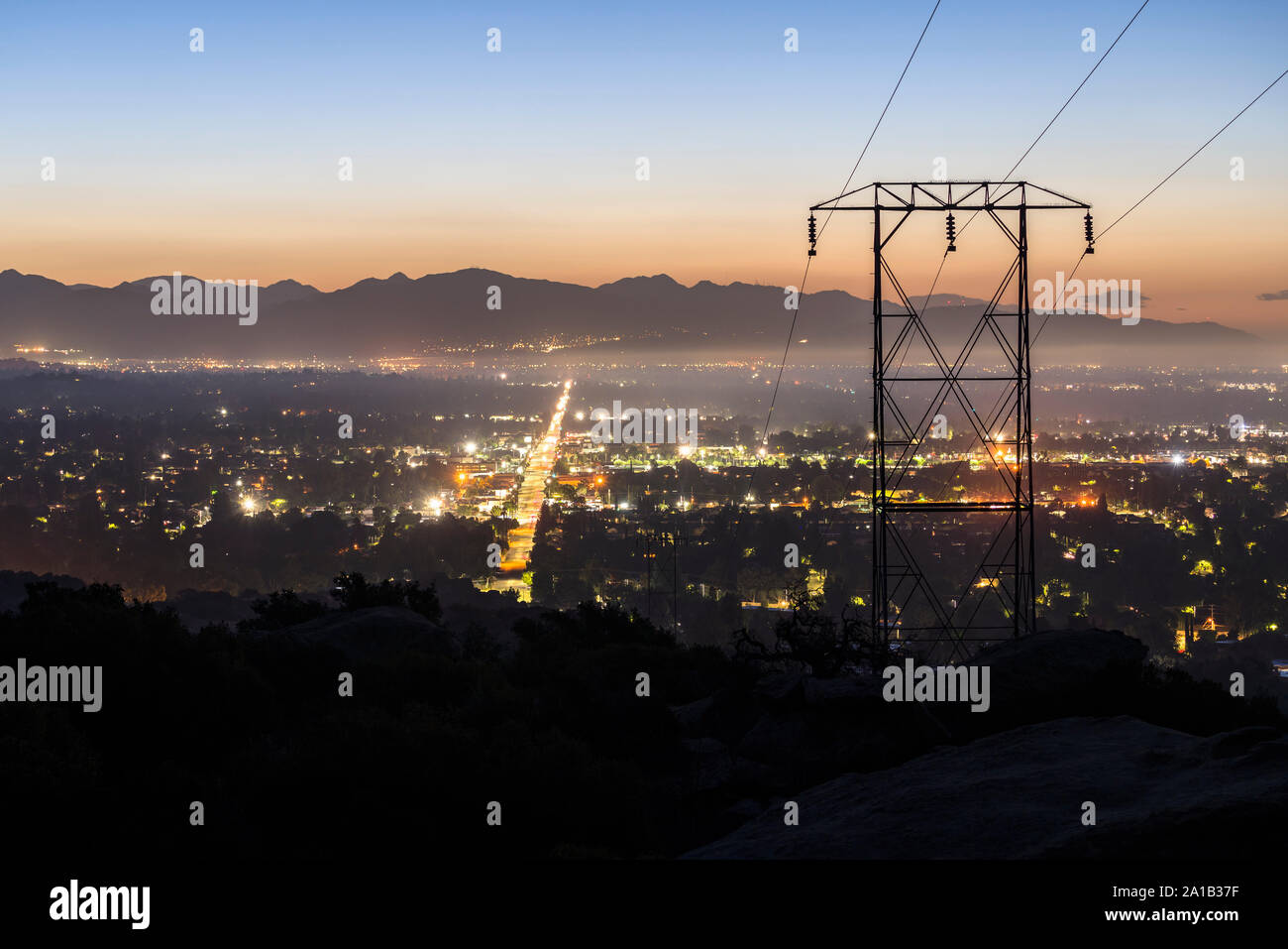 Predawn Ansicht von Stromleitungen in das San Fernando Valley in Los Angeles, Kalifornien. Die San Gabriel Mountains im Hintergrund. Stockfoto