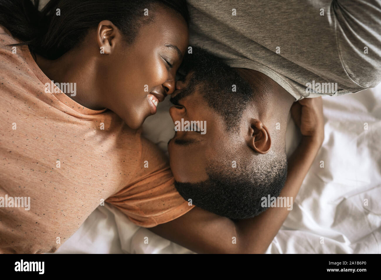 Liebevolle junge afrikanische amerikanische Paar im Bett lag, zusammen Stockfoto