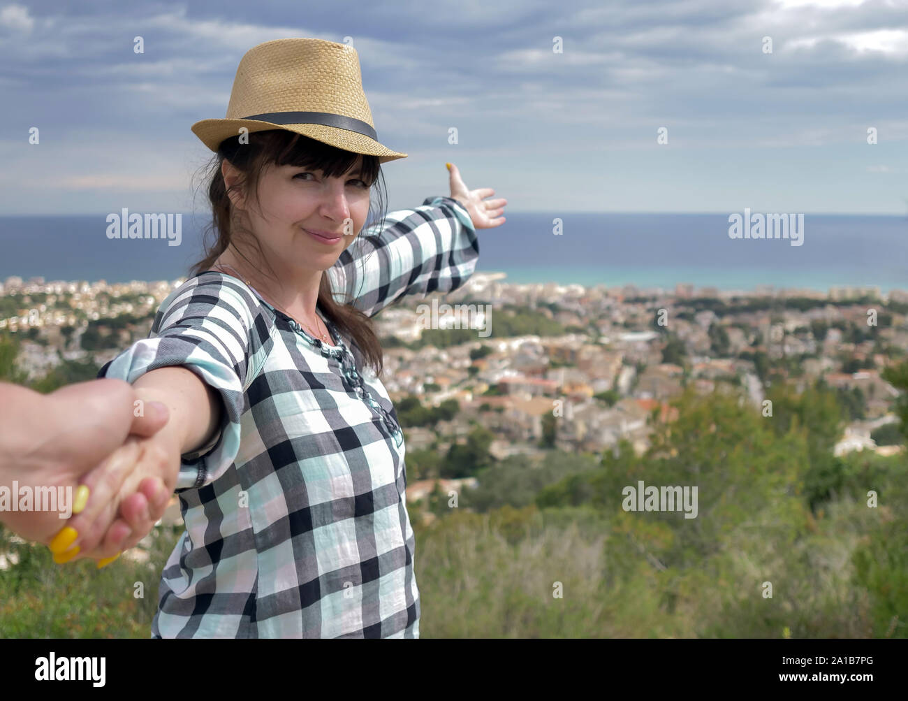 Lächelnd brünette Mädchen führt ein Kerl durch die Hand zeigt eine schöne Aussicht vor Ihnen. Folgen Sie mir das Konzept der Erholung und des Tourismus Stockfoto