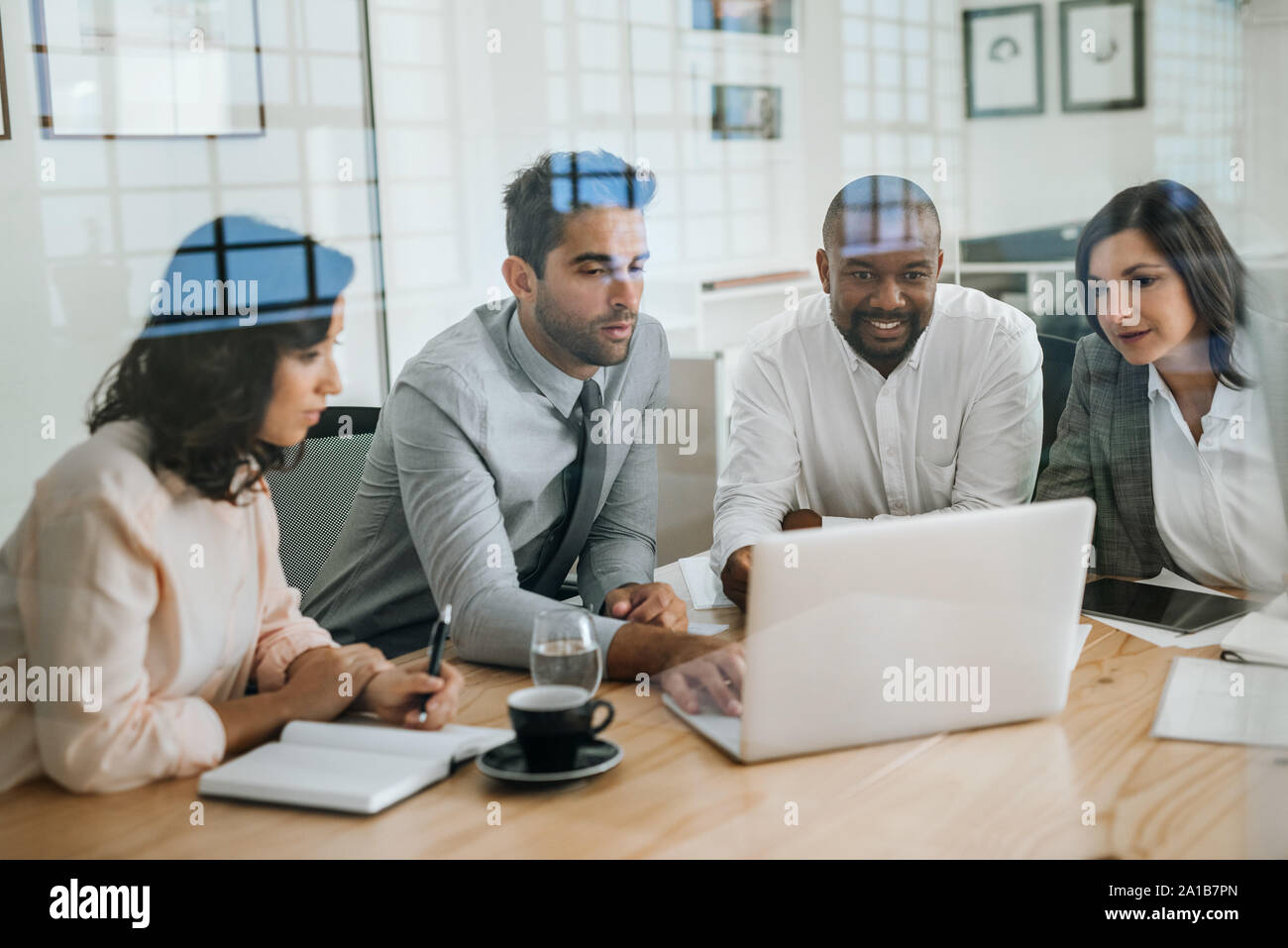 Diverse Kollegen arbeiten mit einem Notebook in einem Büro Stockfoto
