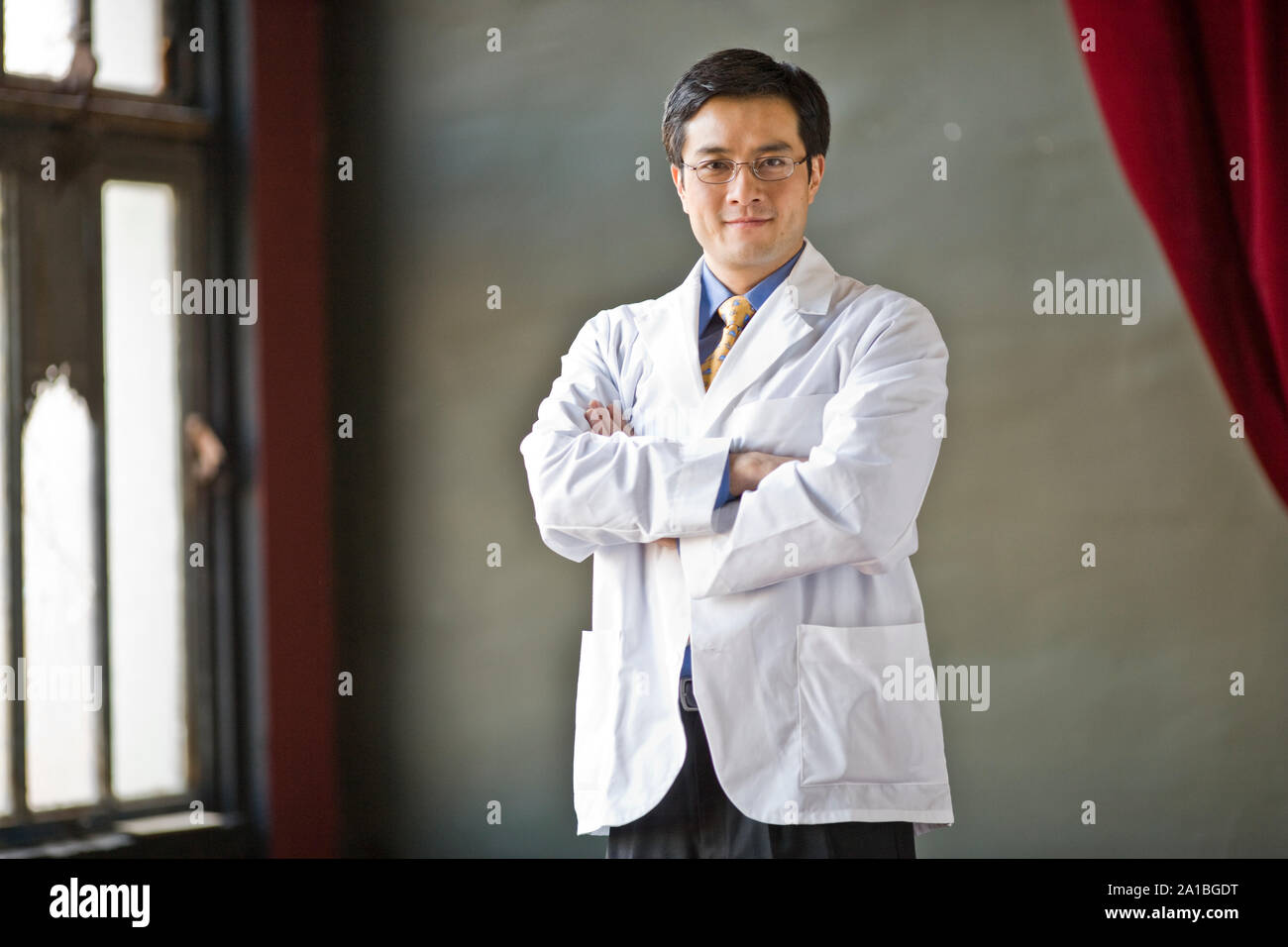 Porträt einer zuversichtlich männlicher Arzt Stehen mit verschränkten Armen. Stockfoto