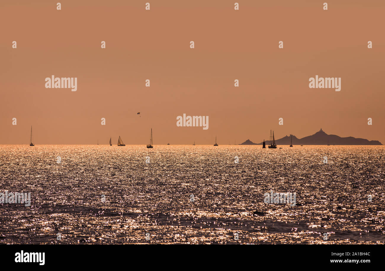 Segelboote und Yachten auf den Meeren bei orange Sonnenuntergang. Korsika, Frankreich Stockfoto