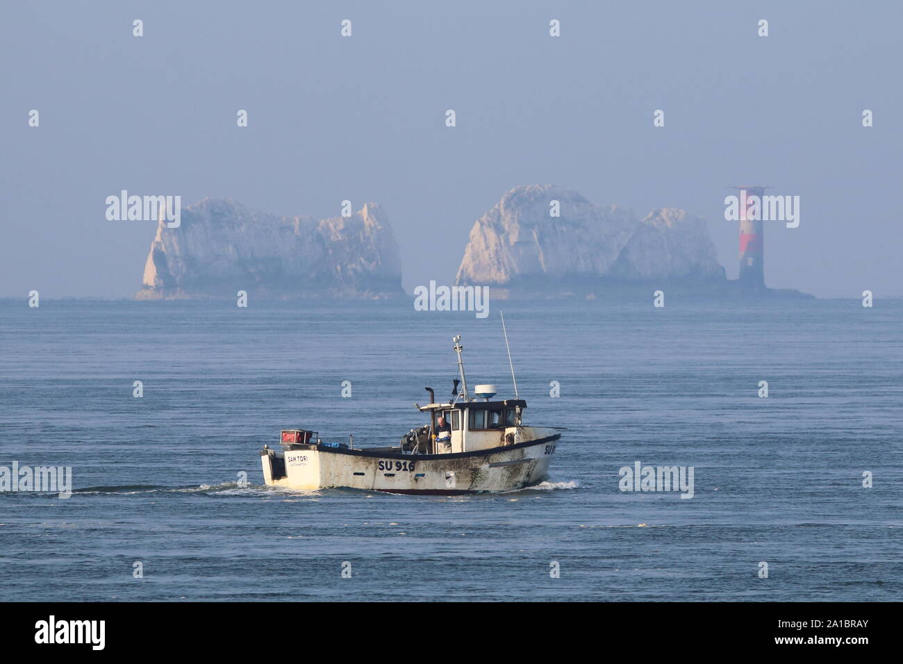 Die Nadeln Leuchtturm, Isle of Wight, mit Fischerboot im Vordergrund Stockfoto