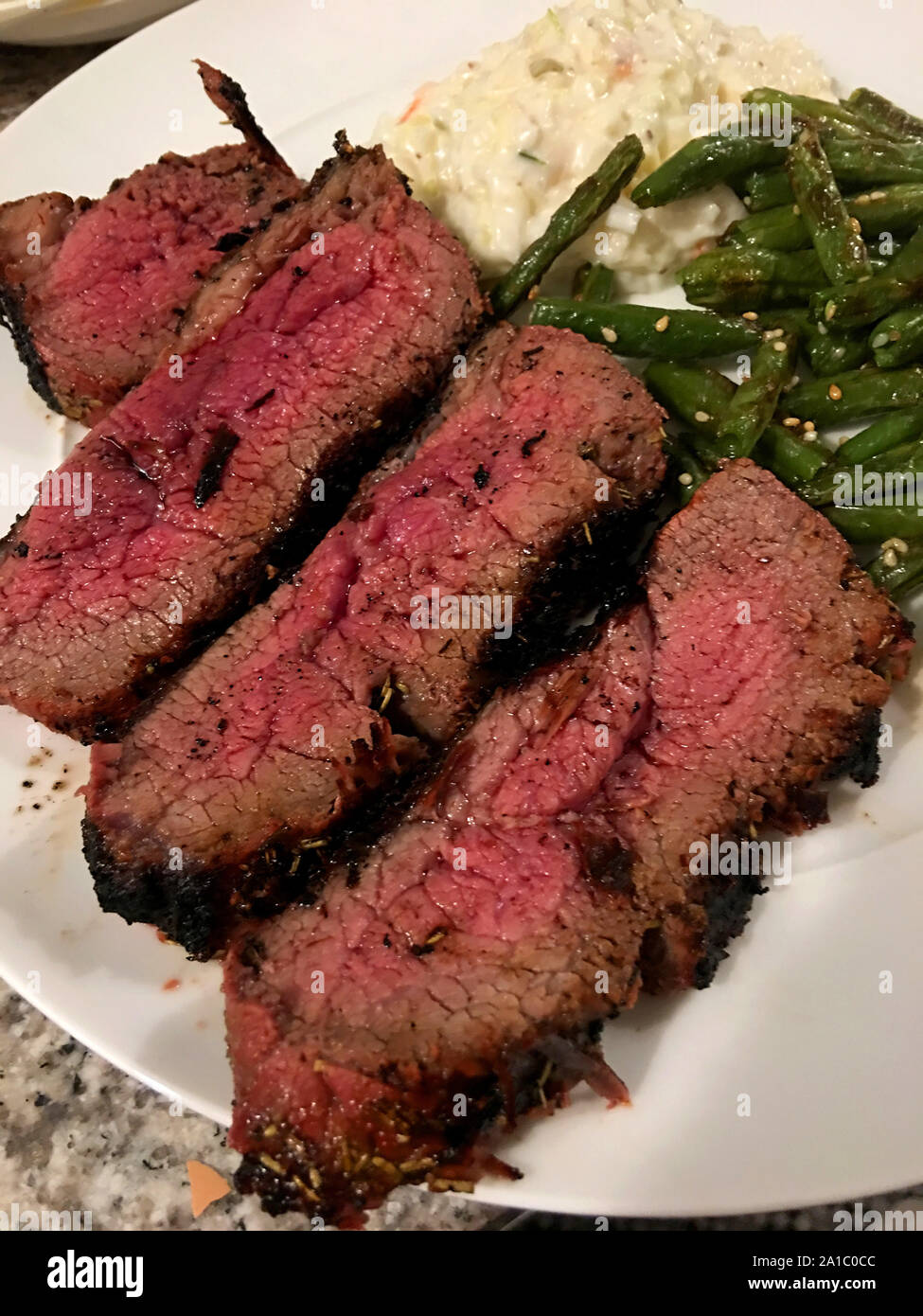Tri - Tipp Rindfleisch mittelfristig gut auf einem weißen Teller mit grünen Bohnen und Krautsalat gekocht Stockfoto