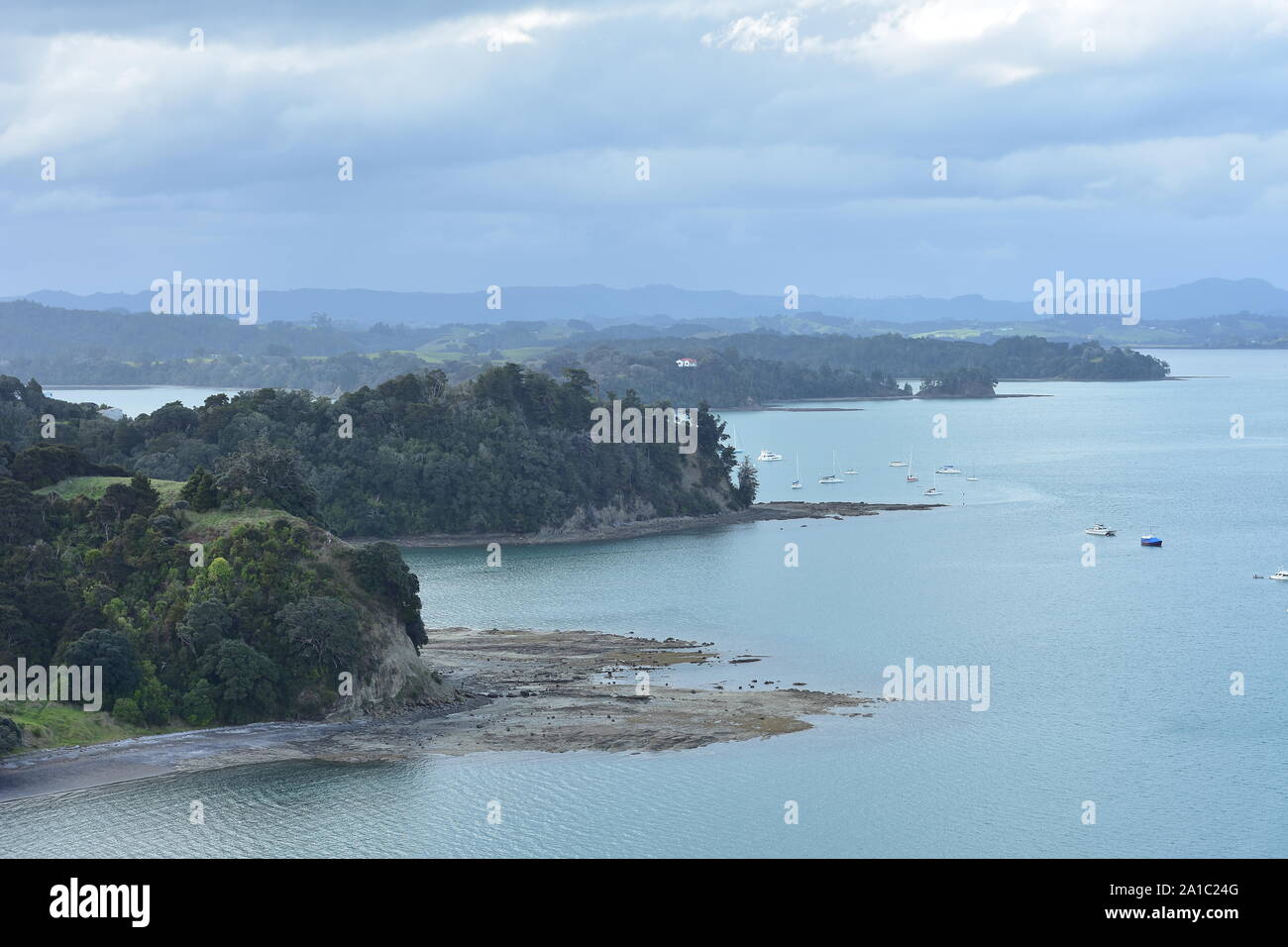 Kleine Buchten und Halbinseln mit felsigen Riffen und Plattformen bei Ebbe freigelegt und günstig Freizeit Schiffe im Hafen in der Nähe von Auckland Mahurangi in Neuen Stockfoto
