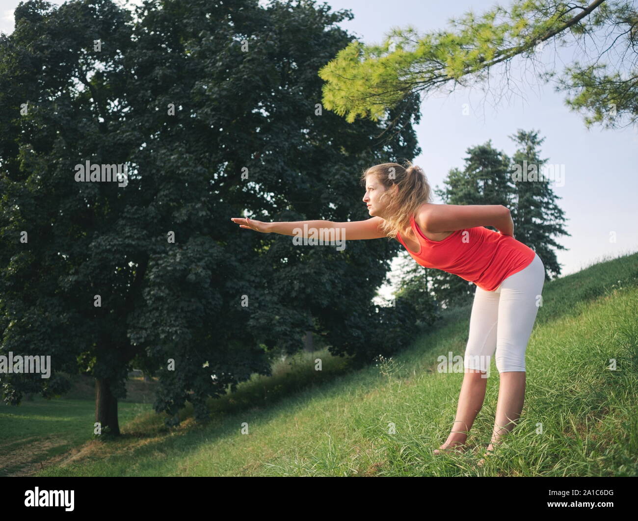 Frau in den 30er Jahren Yoga im Park im Sommer Stockfoto
