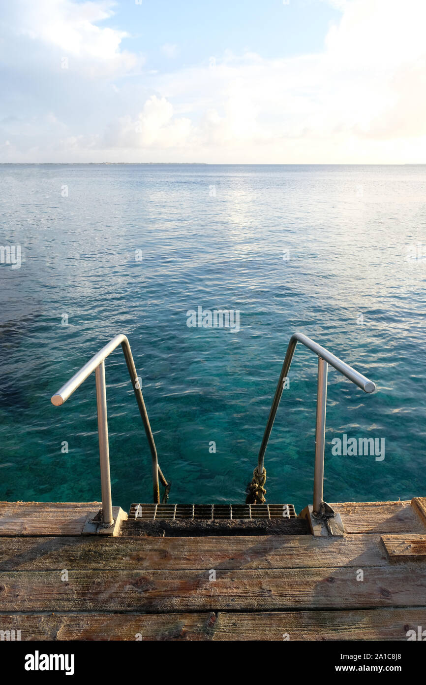 Alte Metall Badeleiter mit blauen tropischen Gewässern Stockfoto