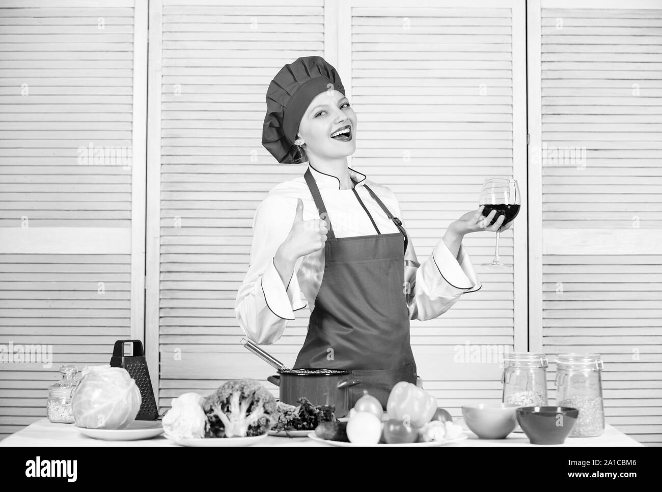 Professioneller Koch in der Küche. glückliche Frau Kochen gesund essen von Rezept. Menü im Restaurant. Nähren. Organische essen und Vegetarisch. Hausfrau. Frau in Cook hat und Schürze. Sauber Essen auswahl. Stockfoto