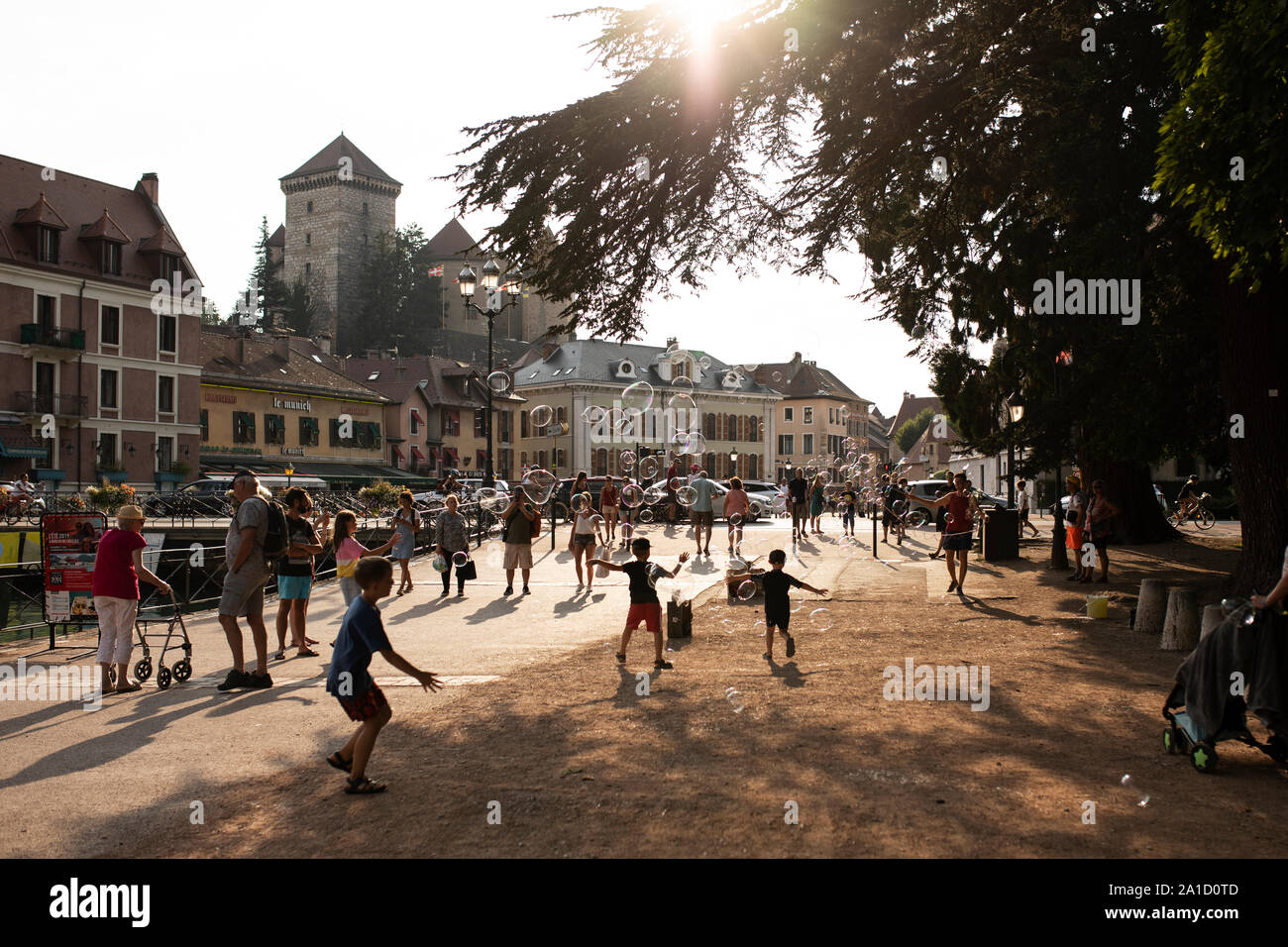 Eine Street Performer bläst riesige Blasen für Kinder auf der Straße an einem Sommerabend in Annecy, Frankreich. Stockfoto