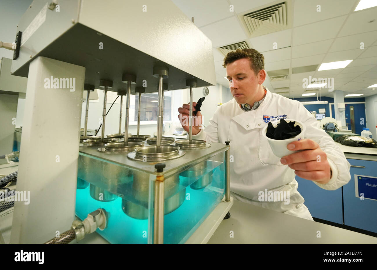 Der Newcastle University PHD-student Max Kelly, 24, an der Benton Proctor & Gamble Website in Newcastle, fügt Segmente des Materials zu einem Labor kontrolliert 'Mini' Waschmaschinen die Freigabe von Mikrofasern in verschiedenen Reinigungszyklen zu messen. Stockfoto