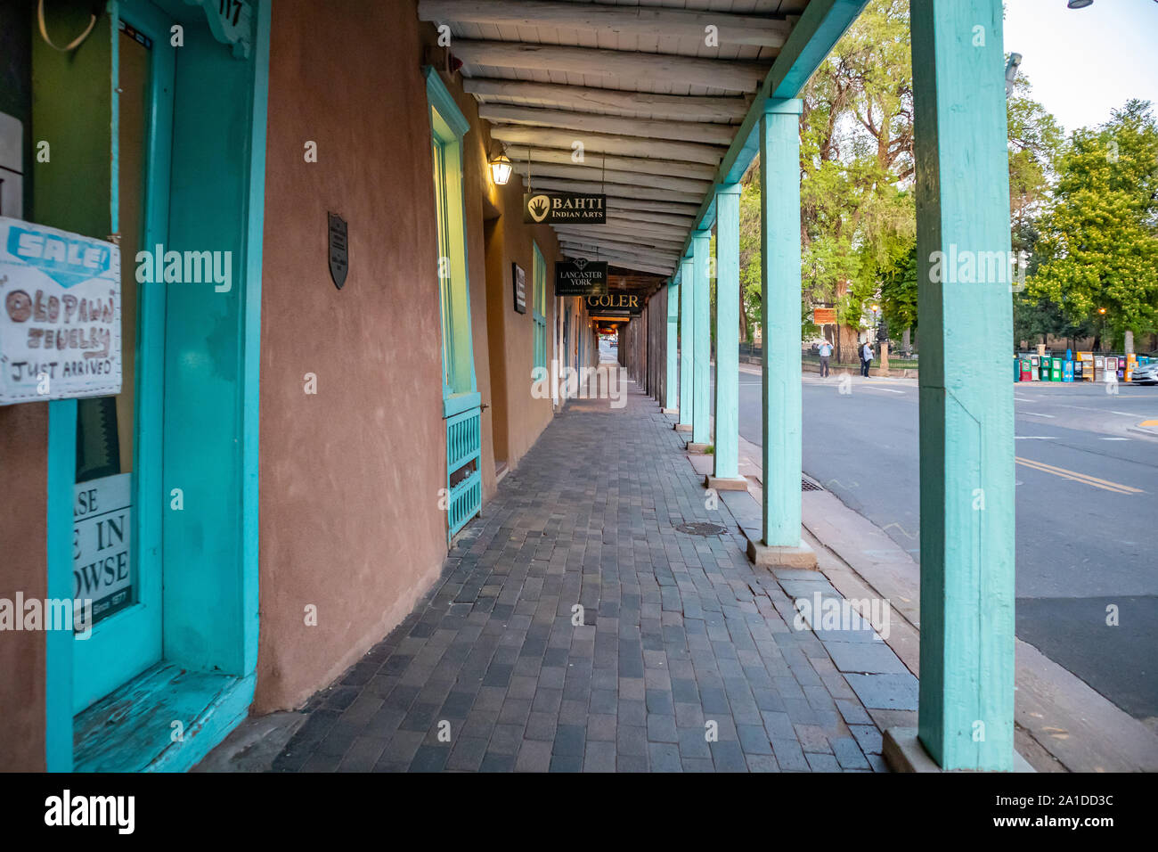 Santa Fe, New Mexico USA. 15. Mai 2019. Traditionelles Gebäude mit überdachten Gang und blaue Spalten in Santa Fe downtown, Sonnenuntergang Stockfoto