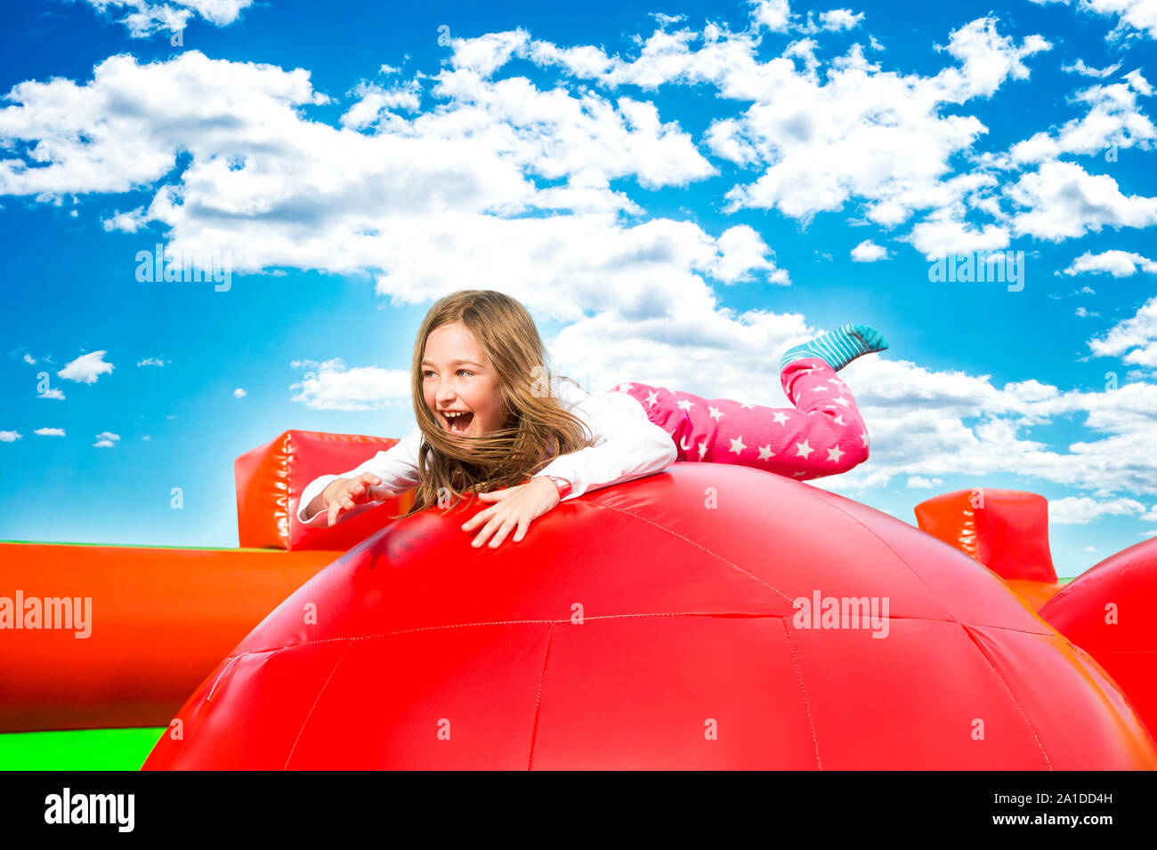 Gerne kleine Mädchen haben viel Spaß auf einem Aufpumpen schloss beim Springen. Stockfoto