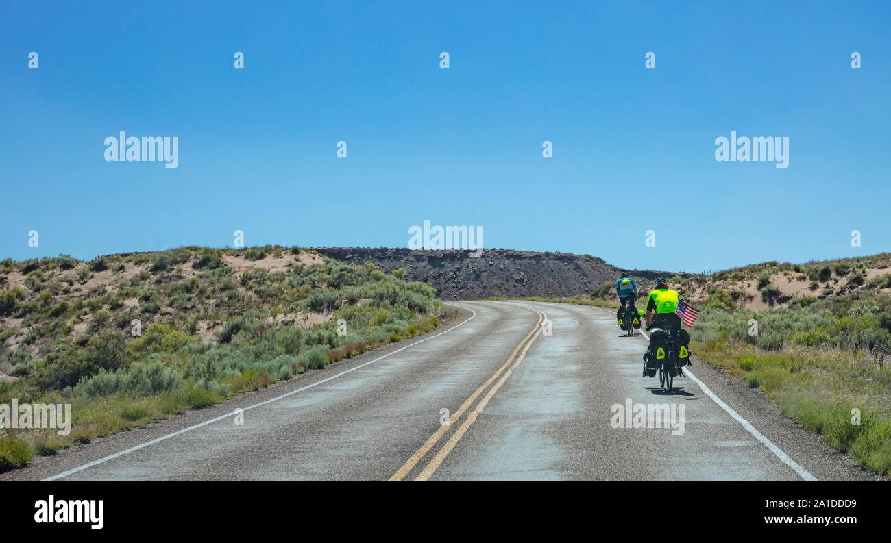 Arizona Landschaft, USA. Mai 25, 2019: Rückansicht der Radfahrer Radfahren in der Nähe der Versteinerte Wald, blue Clear Sky, sonniger Frühlingstag Stockfoto