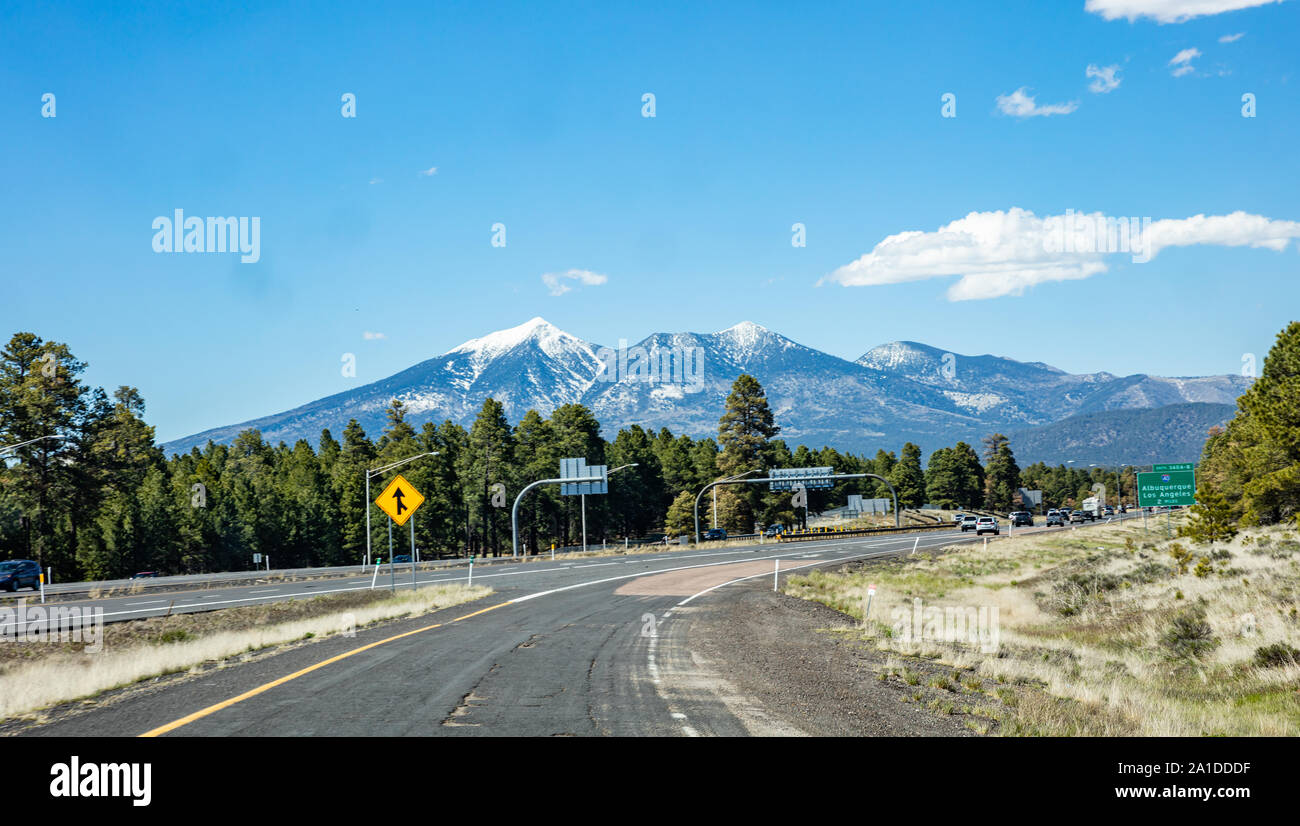 Arizona Highway, USA. Mai 26, 2019: Autobahn in der Nähe von Flagstaff, Schnee auf den Bergen, blauer Himmel, sonniger Frühlingstag Stockfoto
