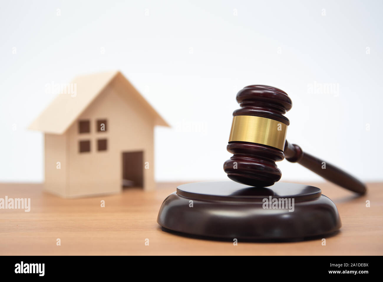 Auktion oder Gesetz Konzept. Miniatur Haus auf Holztisch und Richter Hammer. Stockfoto