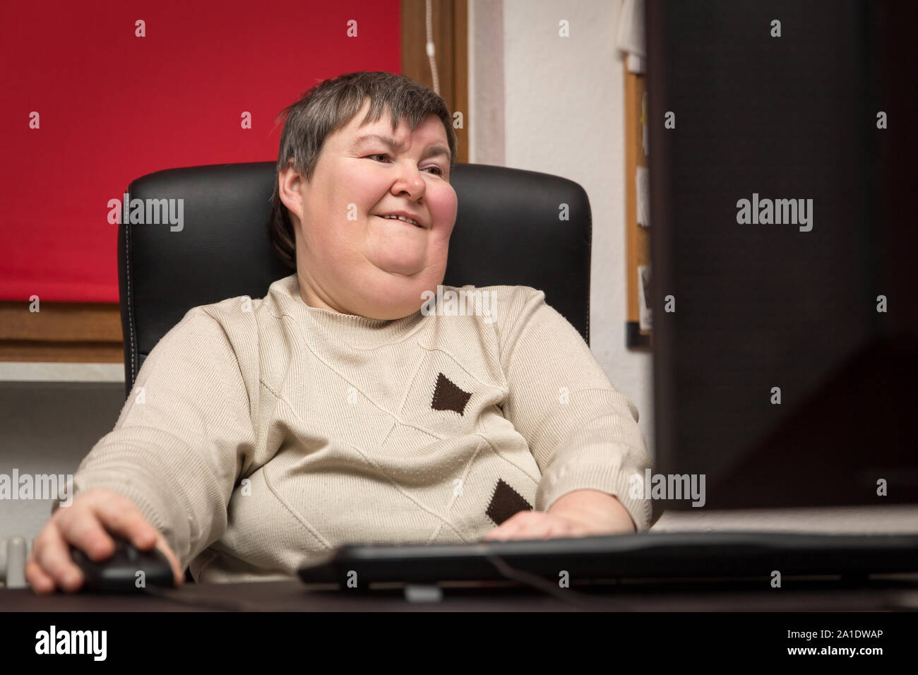 Frau mit einer Behinderung am Computer sitzen zu entwickeln, alternative Therapie und Training Stockfoto