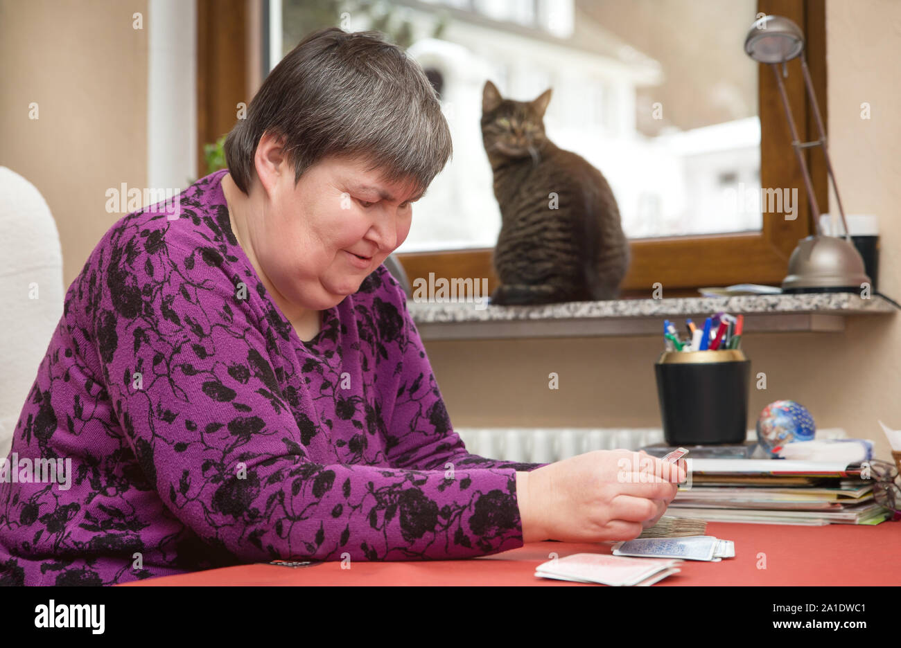 Geistig behinderte Frau, die Karten zu Hause, therapeutische im Alltag Stockfoto