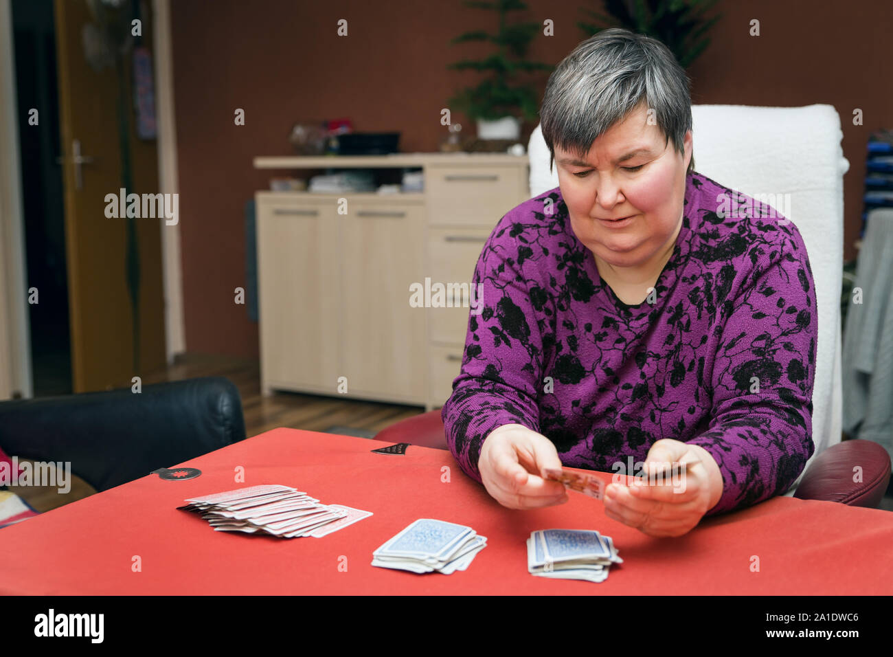Geistig behinderte Frau Spielkarten, Fokus und Konzentration Stockfoto