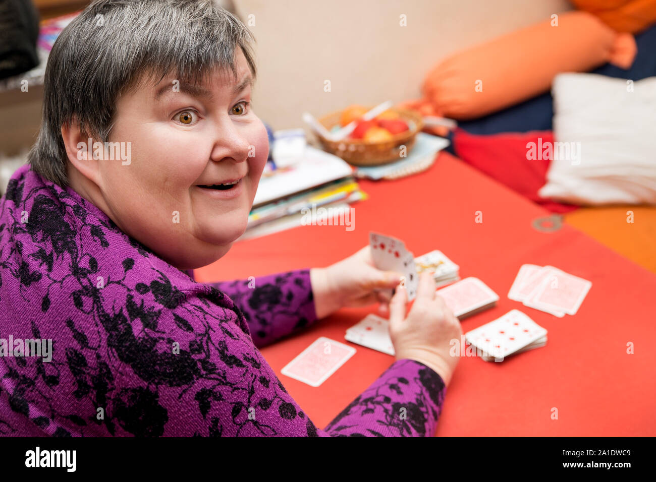 Geistig behinderte Frau, die Karten zu Hause, Glück und Spaß Stockfoto