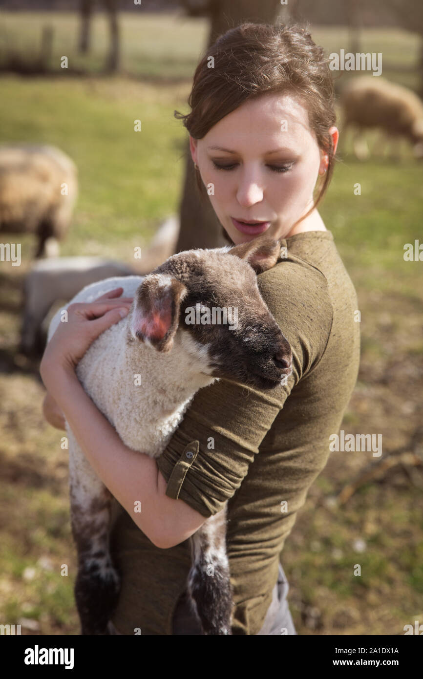 Junge Frau mit einem niedlichen Lammes, Konzept liebevolle Aufzucht und Pflege Stockfoto