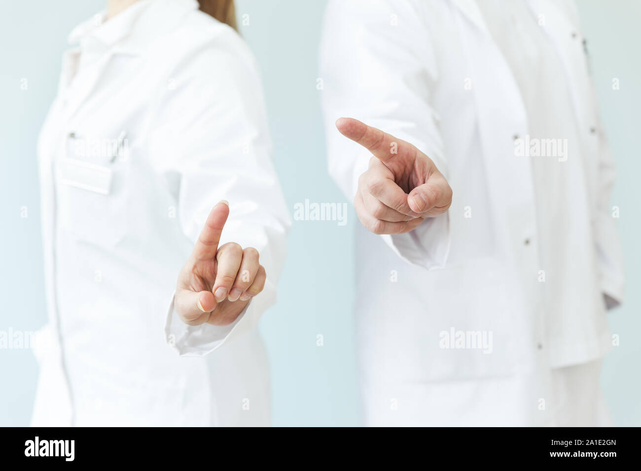 Weibliche und männliche Arzt werden mit Ihren Fingern und Sie vor Ihre bodys. Menge copyspace Konzept Touchscreen oder interaktive Medizin Stockfoto