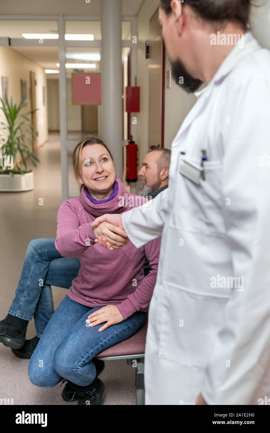 Arzt oder Chirurg gibt eine Frau ein Handshake im Flur oder Wartezimmer eine Klinik oder eine private Praxis Stockfoto