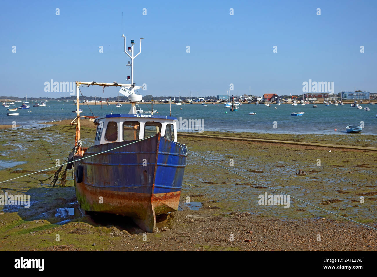 Boot sitzen auf dem Wattenmeer an Eastney auf Milton See mit Hayling Island, Portsmouth, England im Hintergrund. Stockfoto