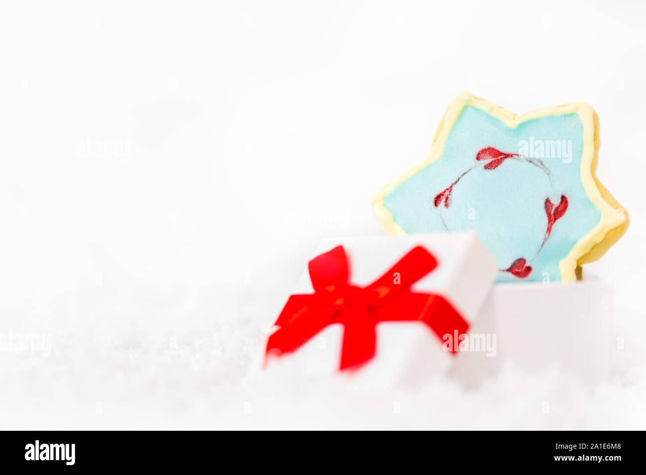 Stern cookies mit Royal icing und einem Geschenkkarton, weisser Hintergrund mit Copyspace Stockfoto
