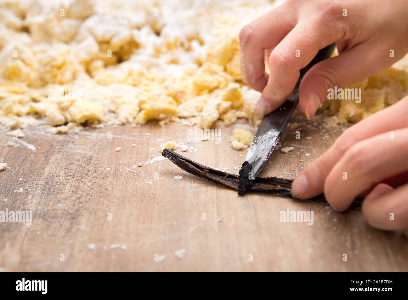 Frau kratzen Vanillemark aus dem Inneren Bean, Plätzchen oder Kuchen Teig im Hintergrund, Copyspace Stockfoto