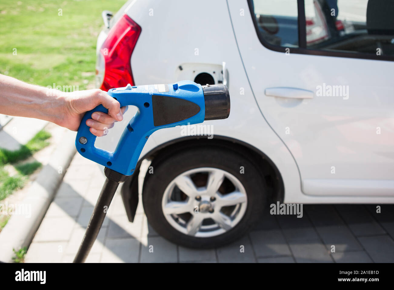 Hand mit ladestecker. Aufladen eines Elektroautos. Stockfoto