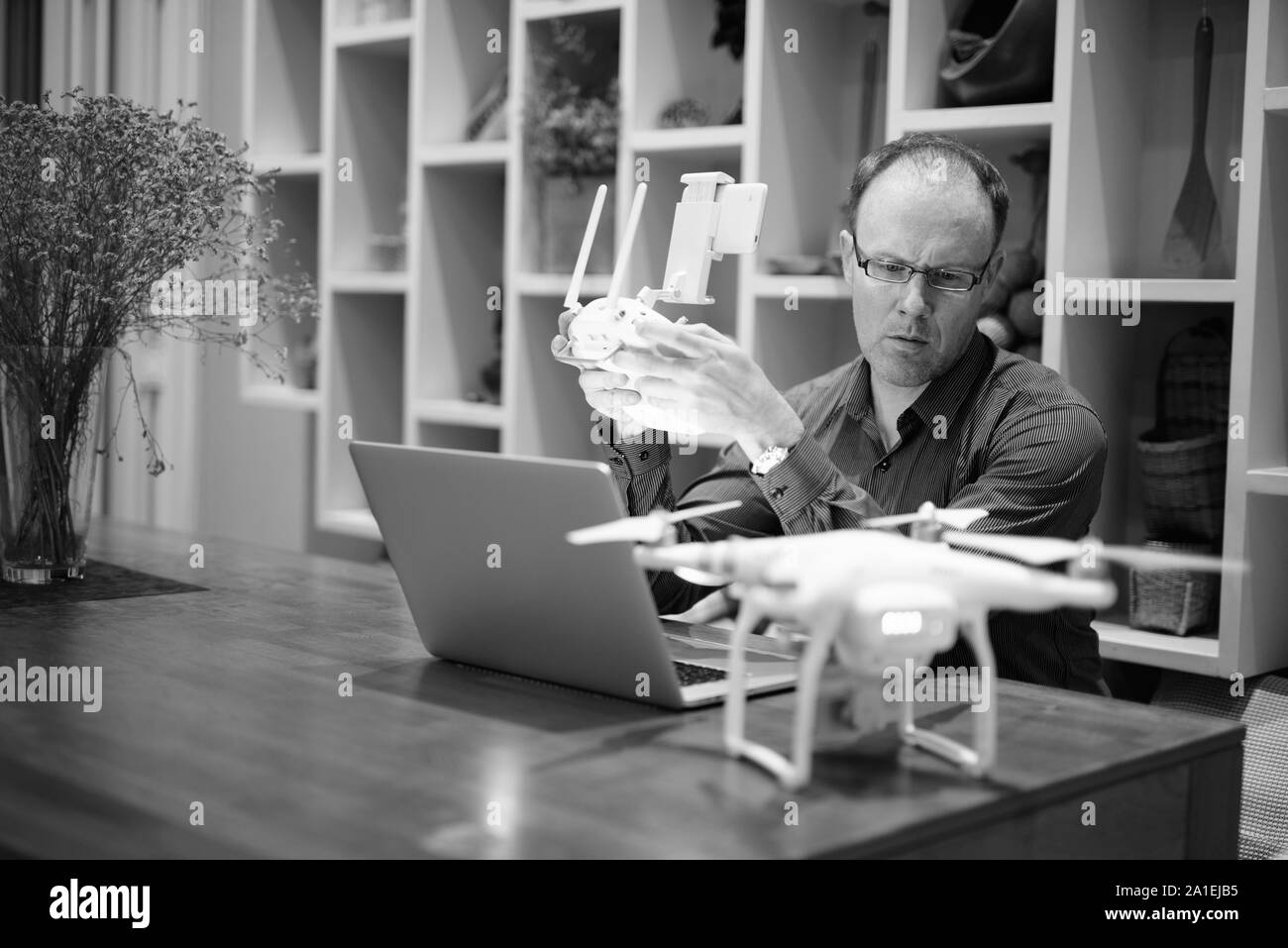 Reifer Mann mit Kamera Drohne mit Laptop Stockfoto