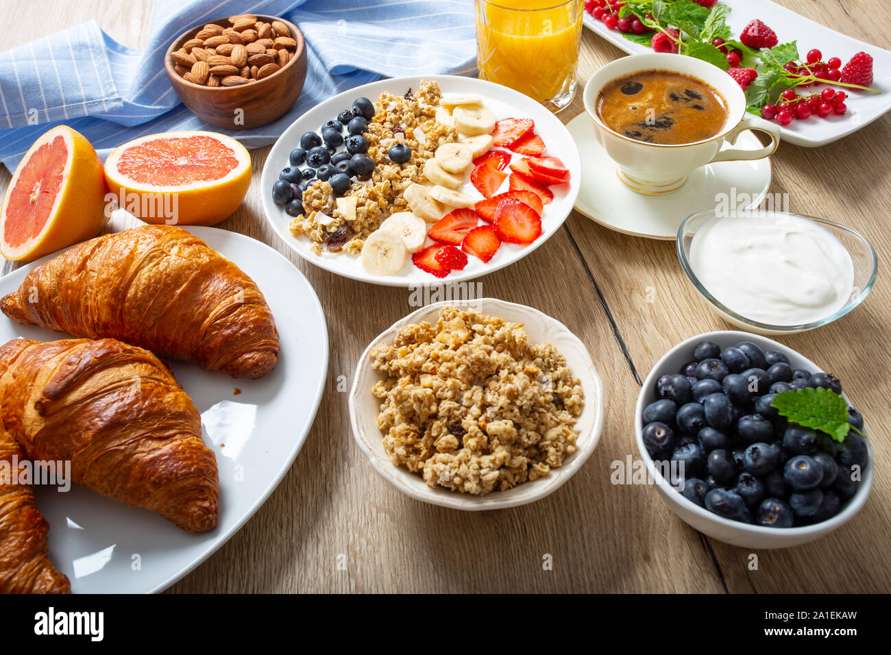 Gesundes Frühstück serviert mit Platte von Joghurt Müsli Blaubeeren Erdbeeren und Bananen. Stockfoto