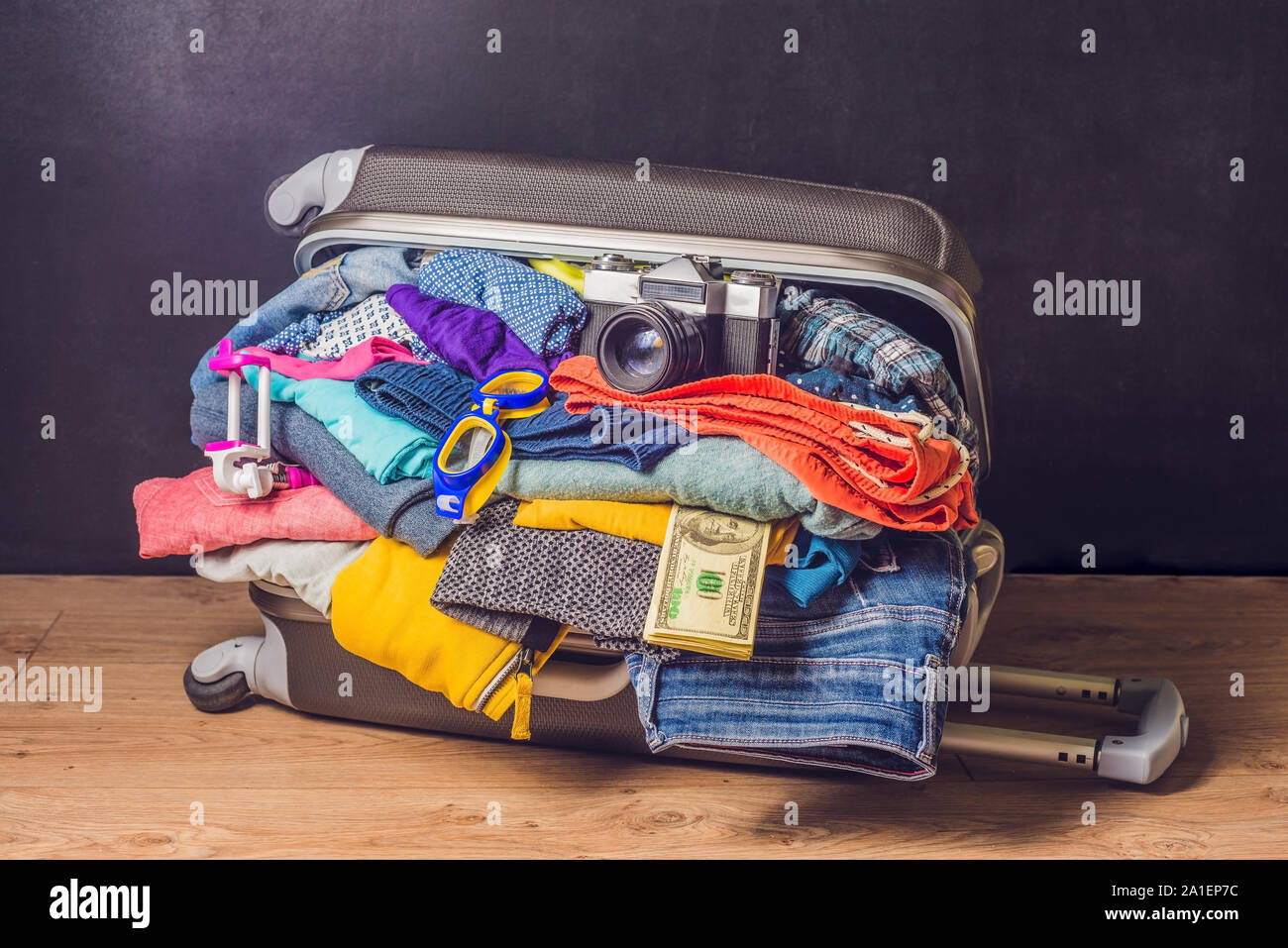 Gepackte Koffer mit Zubehör und Geld für Holz- Hintergrund Stockfotografie  - Alamy