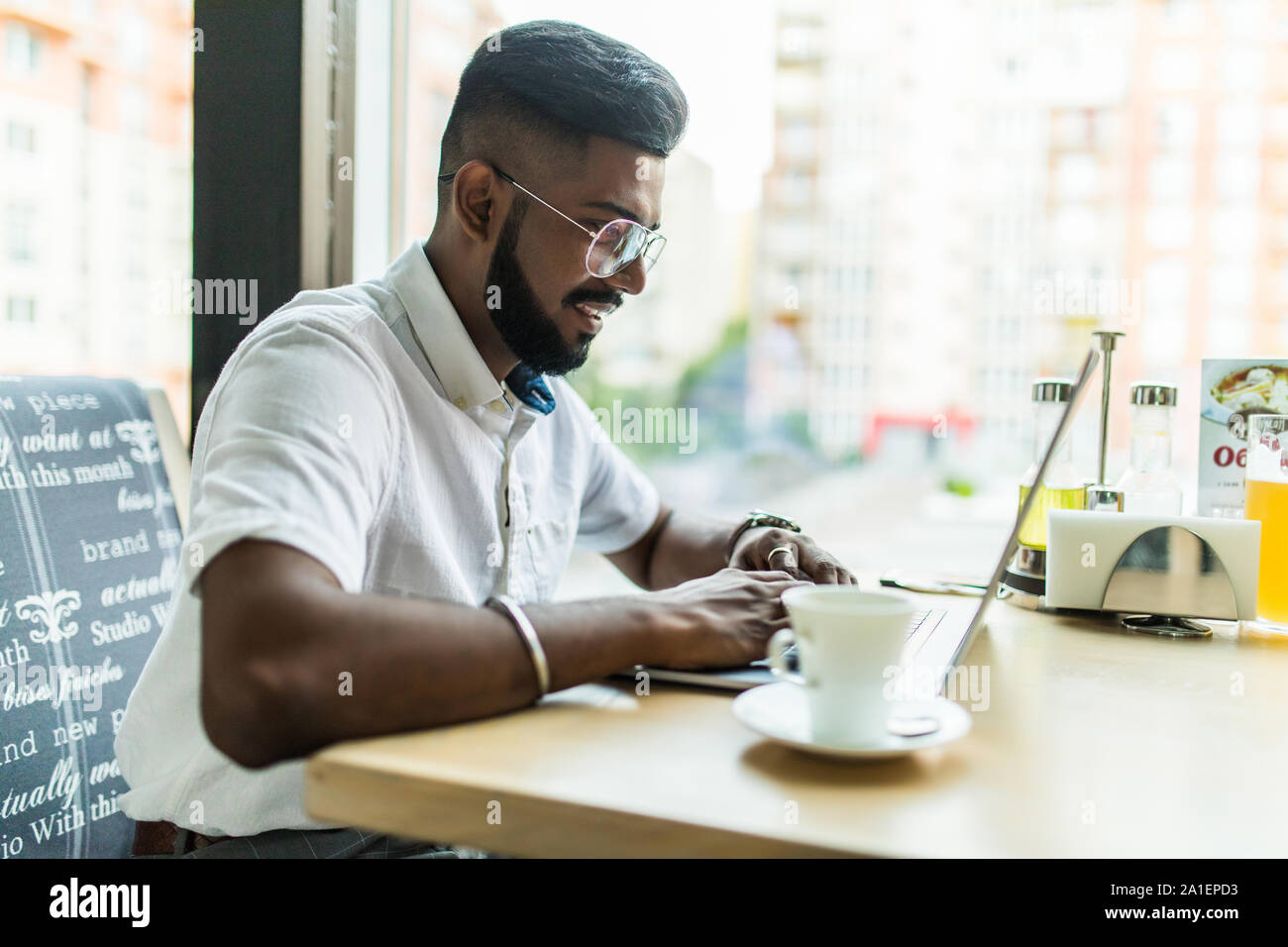 Qualifizierte stattliche männliche Kursteilnehmer der IT Programmierung Schule online üben Übung in der Codierung der Texteingabe auf Laptop Tastatur im Cafe sitzen Stockfoto