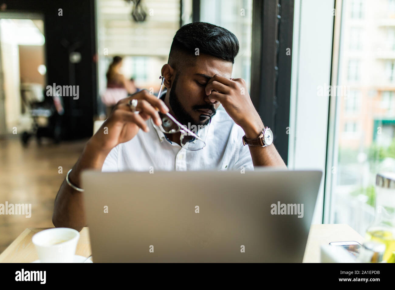 Junge asiatische Geschäftsmann leiden müde Augen nach langen Stunden des Laptop verwenden. Stockfoto