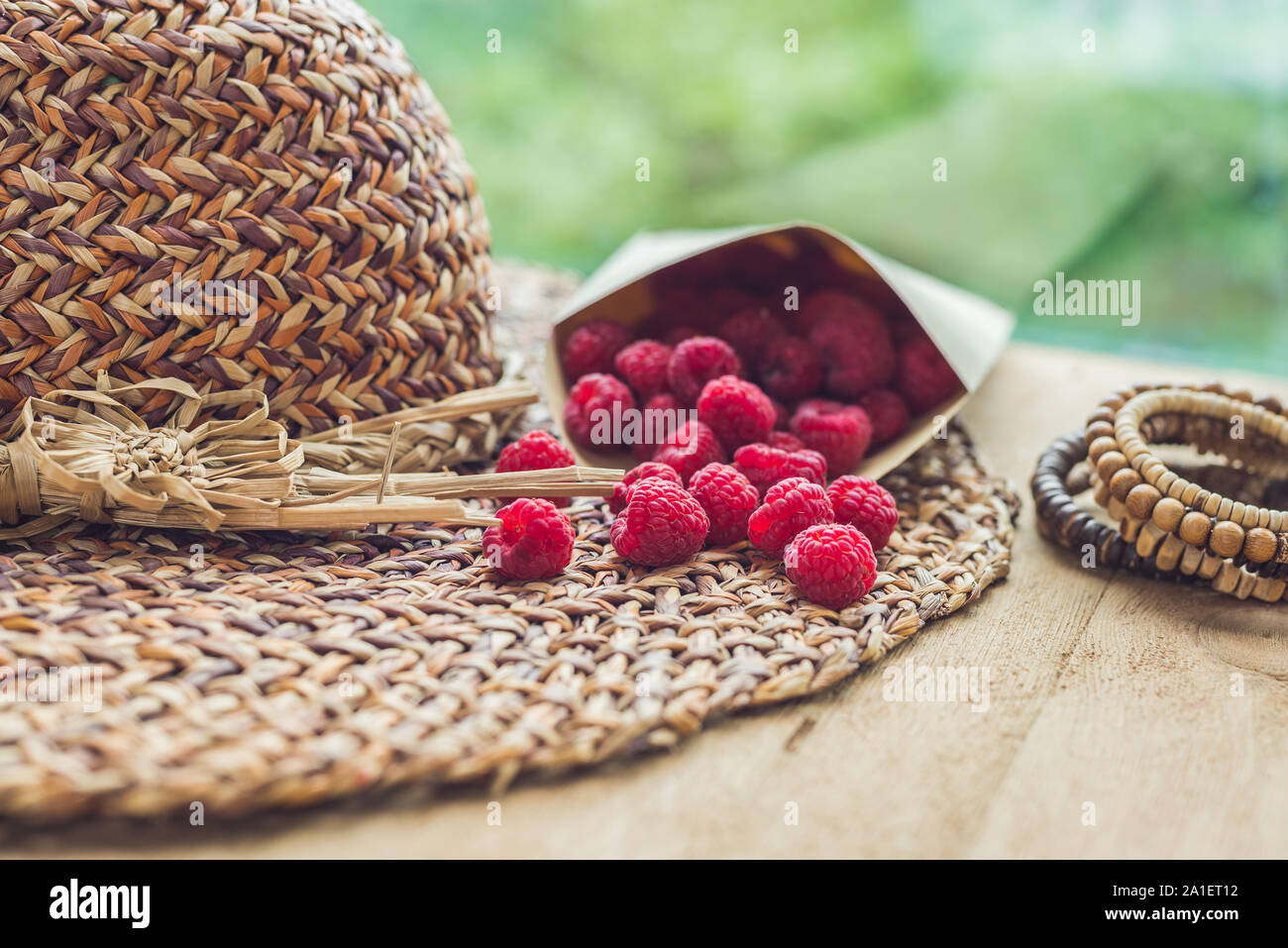 Sommer Urlaub, Ferien, Entspannung Konzept. Himbeeren, Stroh Hut, auf Holz- Hintergrund. Freier Text kopieren. Sommer vibes Konzept Stockfoto