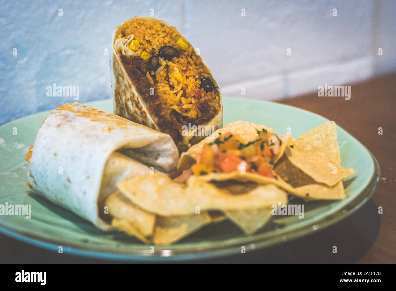 Doppel Chili Cheese Beef Burrito Ausschreibung zog Rindfleisch, Mozzarella schwarze Bohnen, und mexikanische Reis in einem Mehl Tortilla mit Tortilla Chips serviert gewickelt Stockfoto