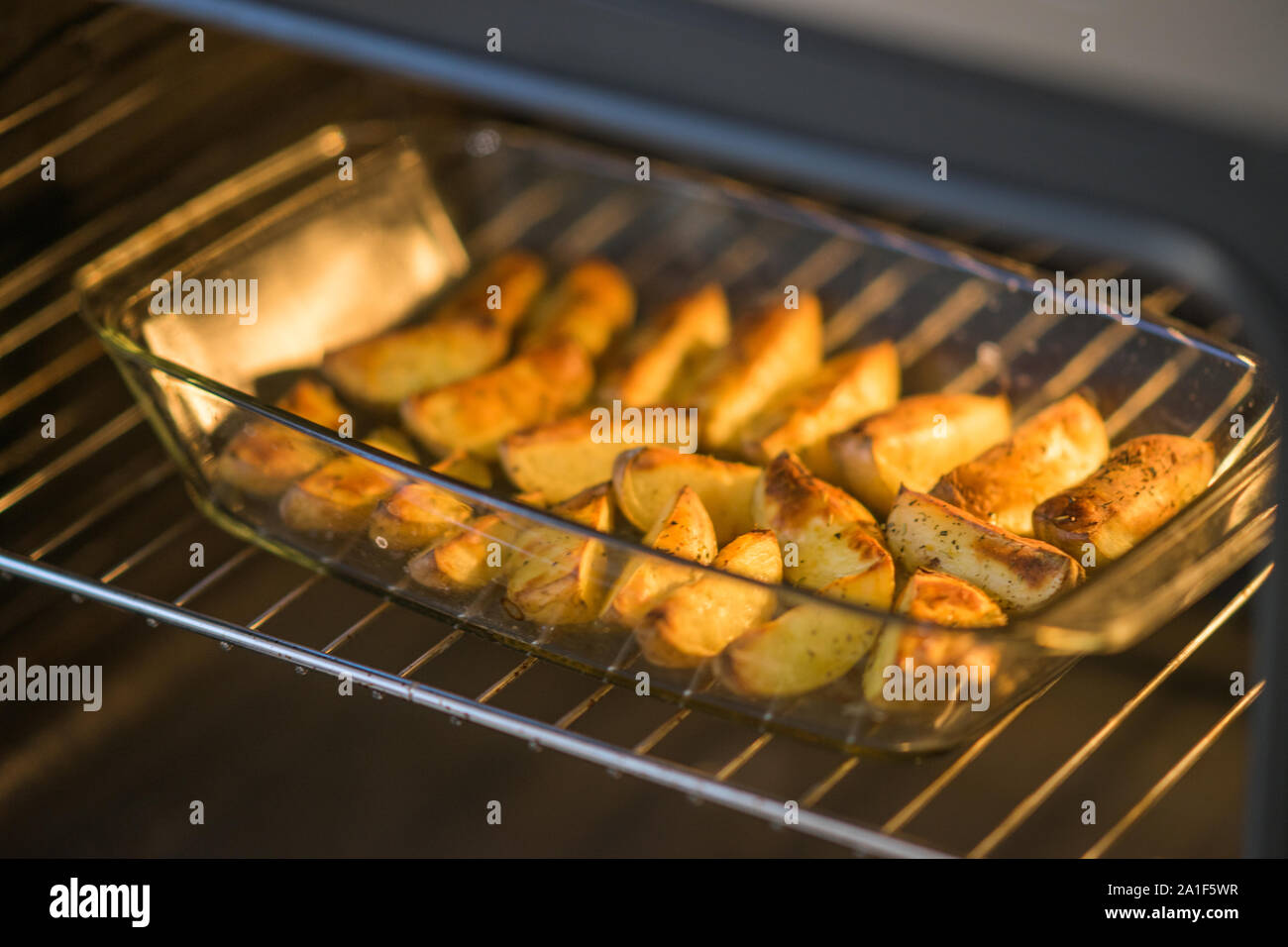 Fertig gebackene Kartoffelscheiben mit Gewürzen liegen in Glas Teller im  Ofen Stockfotografie - Alamy